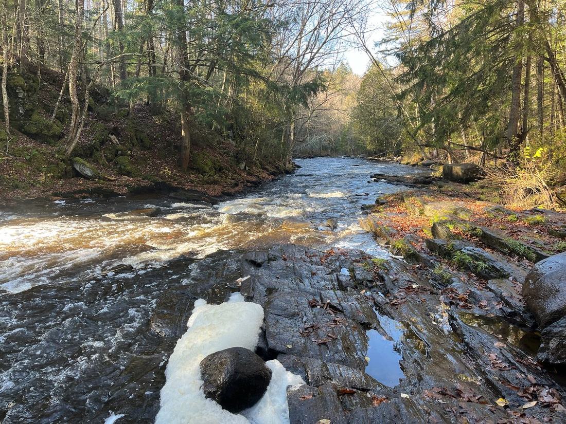 A small waterfall running over rock in the woods